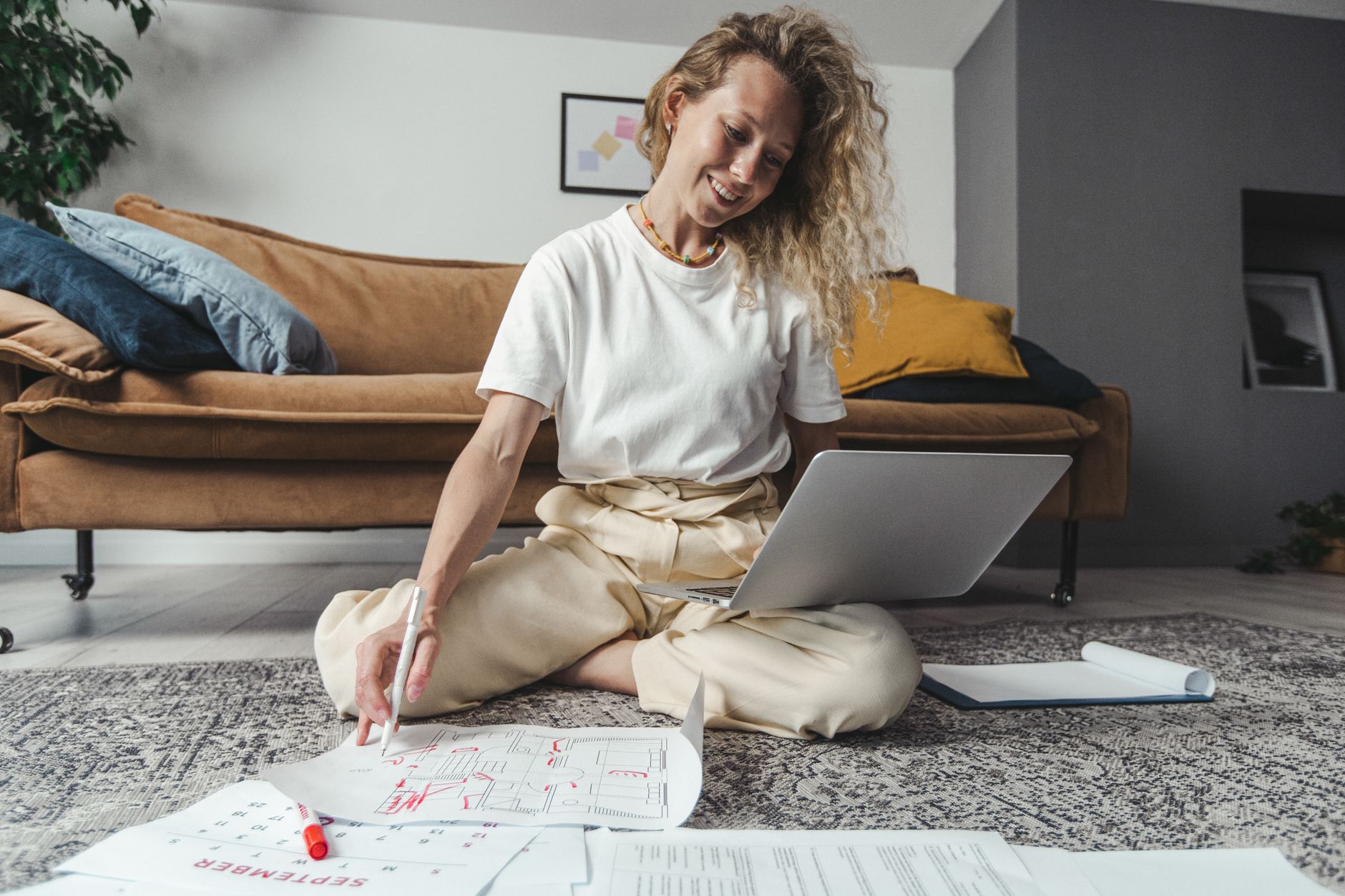 a woman using a laptop while sitting on the floor
